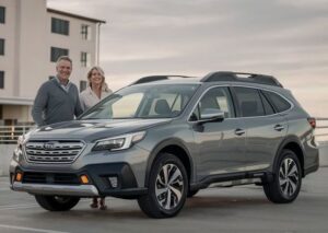 Couple-standing-next-to-thier-Subaru-in-a-parking-lot-after-repair-at-Dingsmans