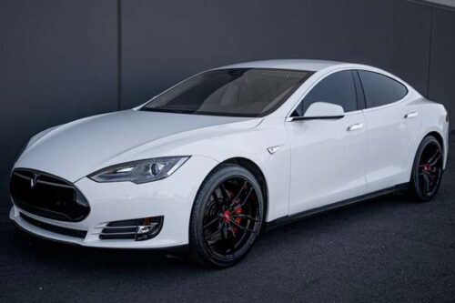 Tesla-Approved-Repair-Omaha-White-Tesla-Sedan silver-2025-Cadillac-CTV-showroom-setting-GM-Certified-Collision-Repair
